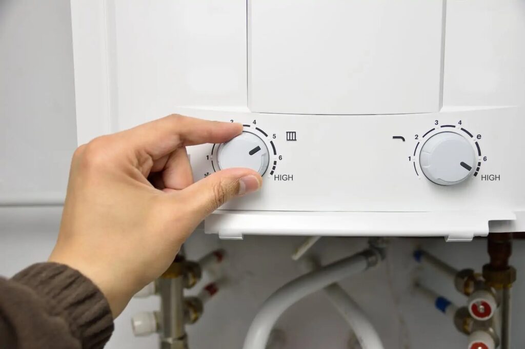 Technician adjusting dial on tankless water heater